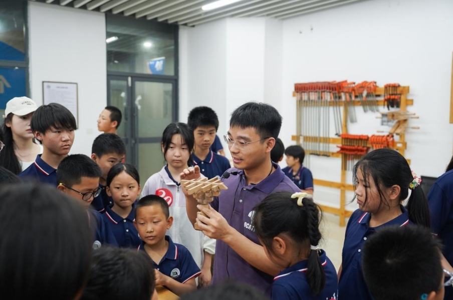 beat365正版唯一官网必一基础实验与工程实践中心老师正在给研学团成员讲解榫卯工艺。